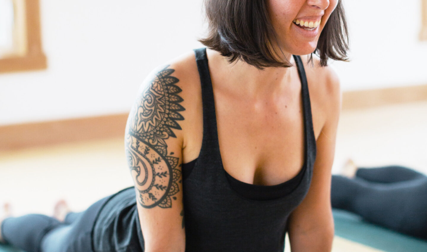 Woman practicing yoga and smiling.