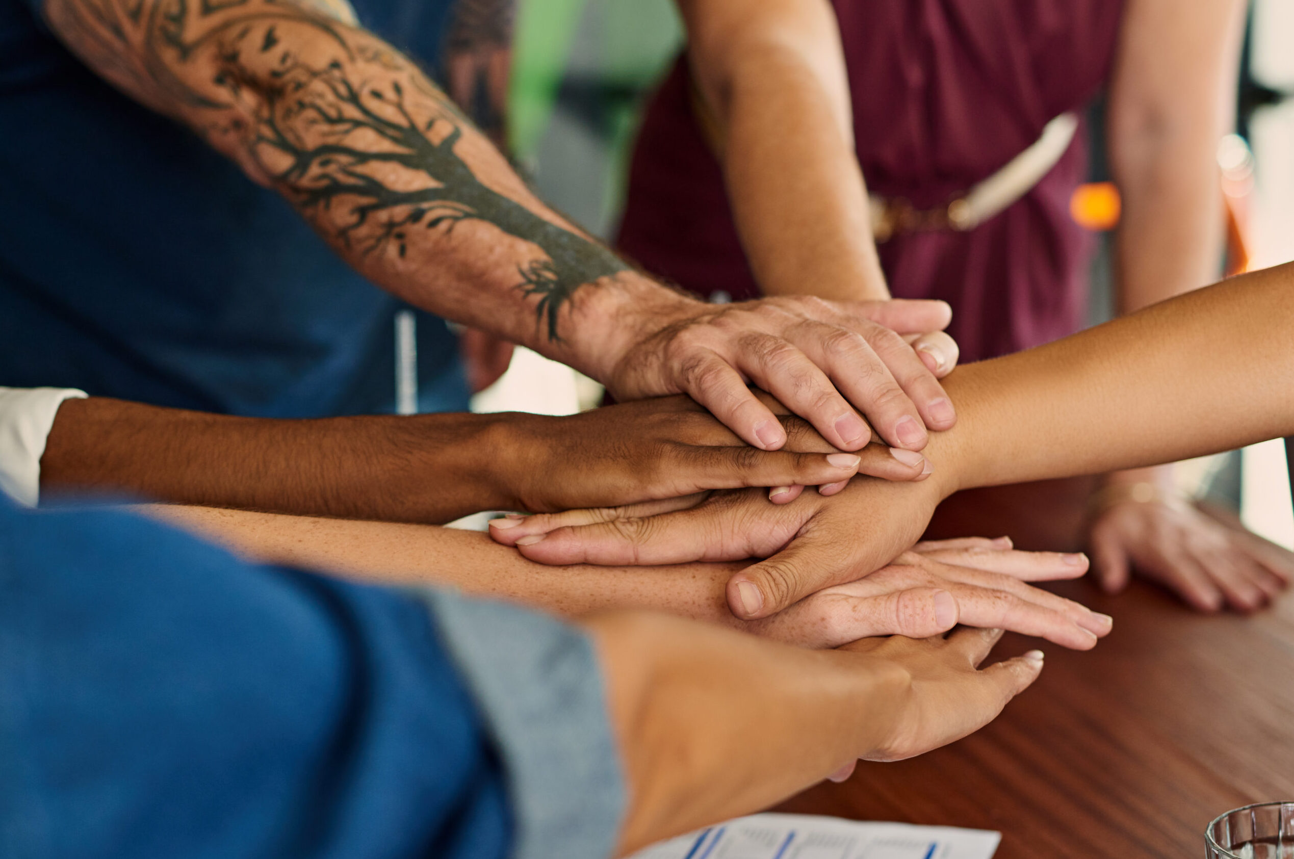 Closeup shot of an unrecognizable group of businesspeople joining their hands in a huddle